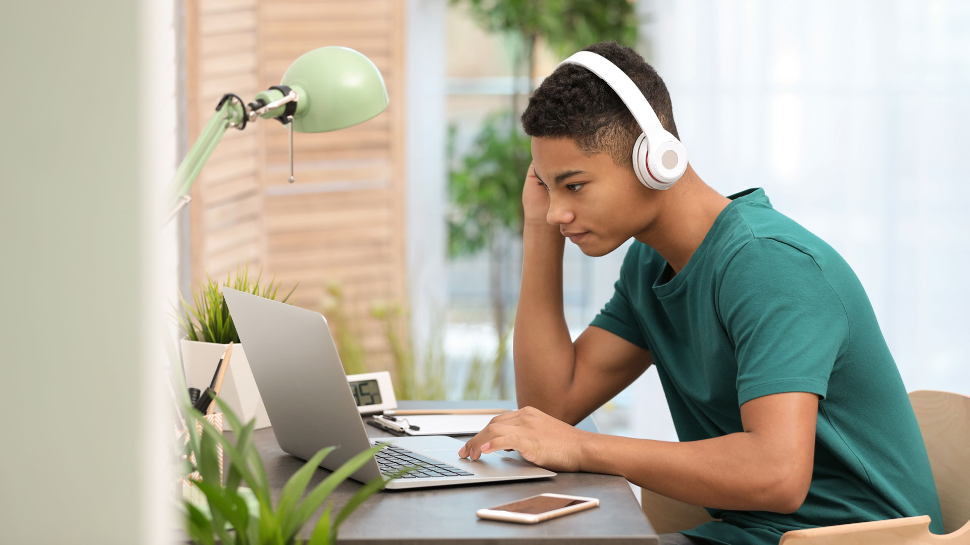School student connecting to an online class on a laptop at home.