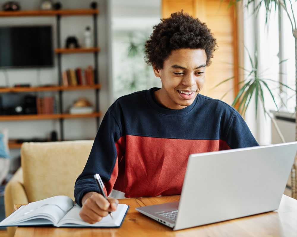 Middle school student connecting to an online class on a laptop at home.