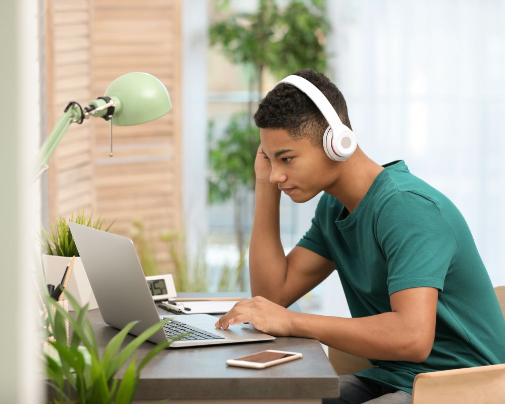 Middle school student connecting to an online class on a laptop at home.